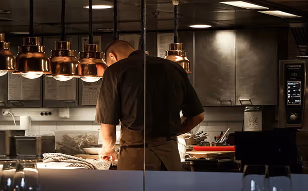 Chef cuisinant de dos dans un restaurant
